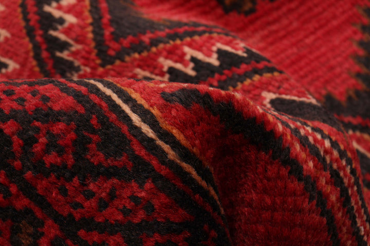 Detailed close-up of the fine geometric motifs in red and black, showcasing the craftsmanship of the Afghan wool runner.