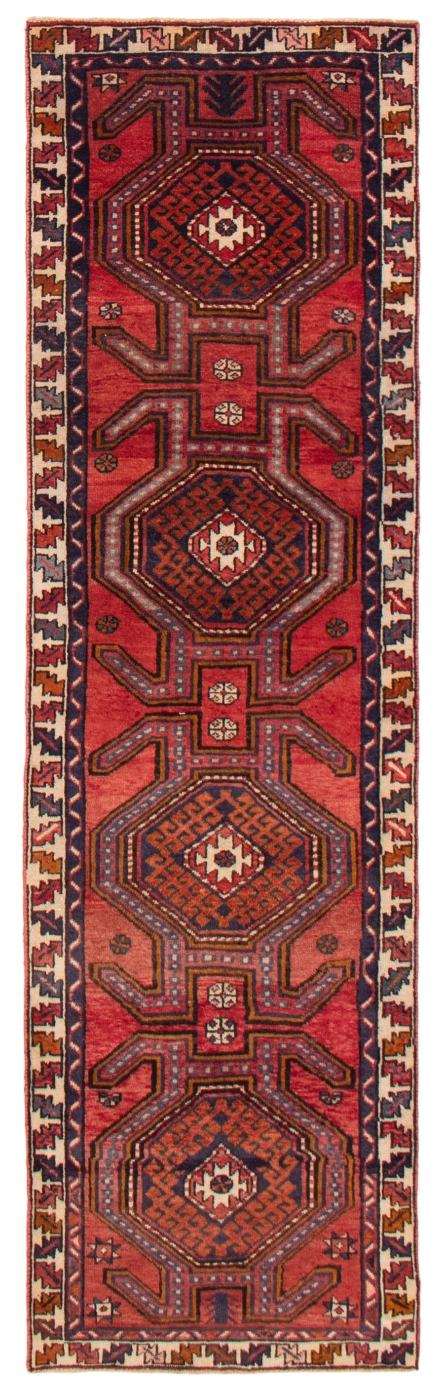 A hand-knotted Turkish wool runner featuring geometric hexagonal patterns in deep reds and blues. Available at Tuck Rugs.