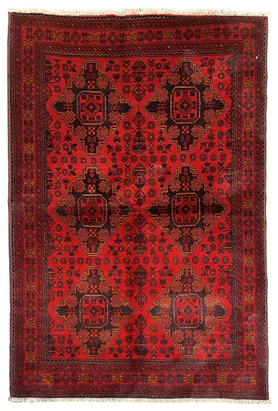 The Canterbury Afghan wool rug with intricate geometric designs in rich red and dark tones. Available at Tuck Rugs.