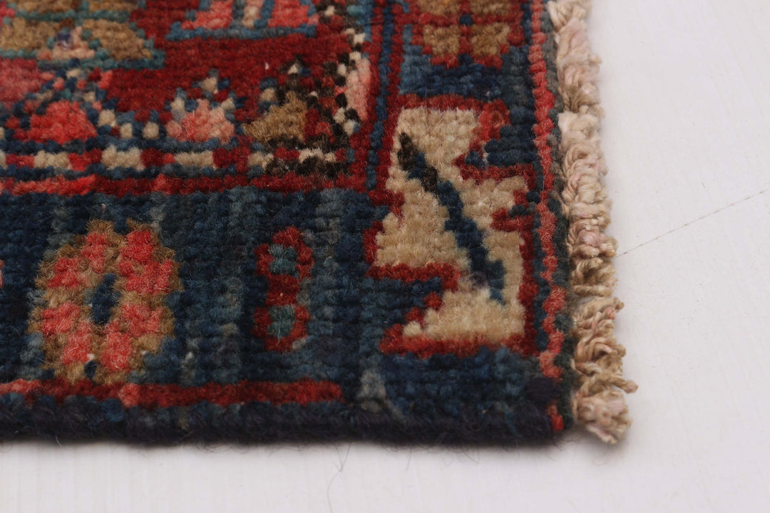 Close-up of the rug's edge with detailed weave and red-blue border designs. Available at Tuck Rugs.