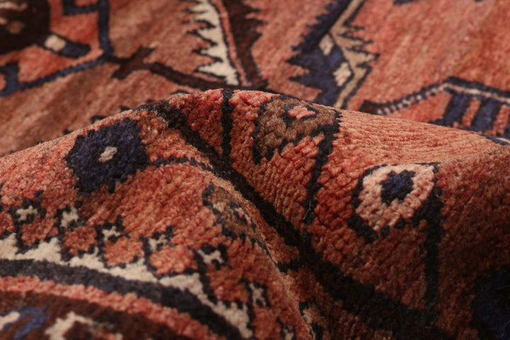 Close-up view of The Carleton Rug’s intricate hand-knotted patterns, showcasing rich brown and red tones. Available at Tuck Rugs.