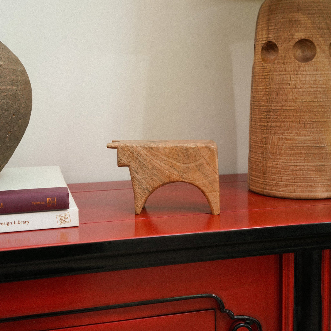 Wooden lamp and decorative object on a red surface with a neutral background