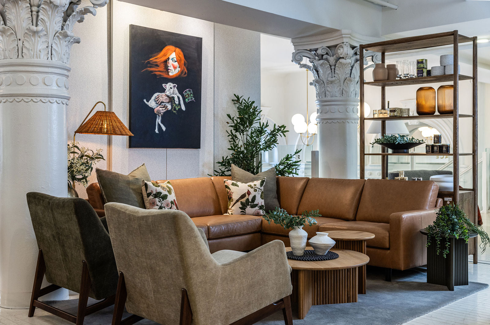 Modern living room with brown leather sectional sofa, armchairs, and decorative elements.