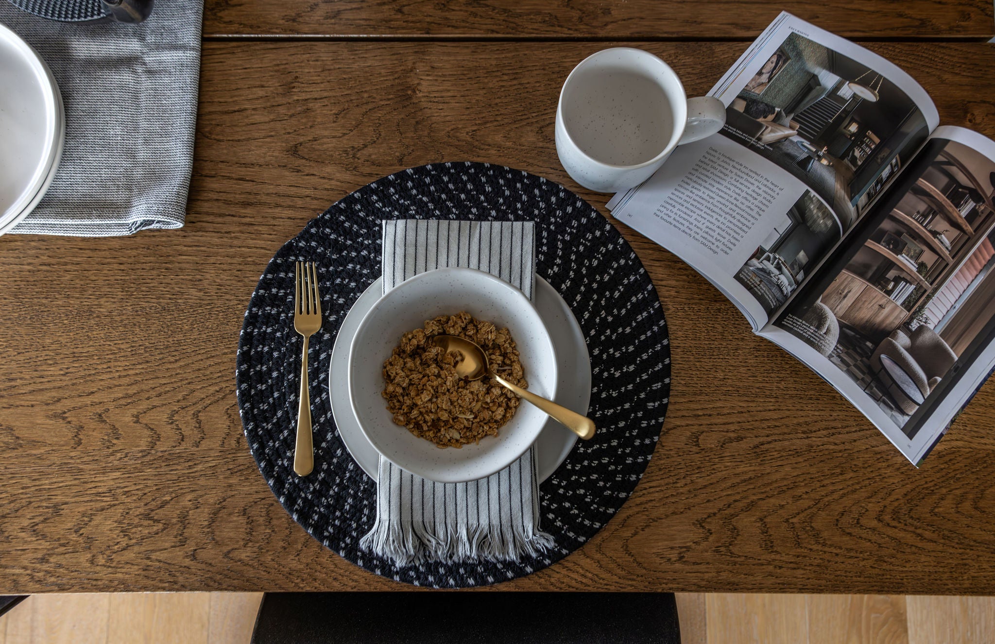 photo - Fable bowl and coffee cup sitting on a table set for breakfast with granolas in the bowl and a magazine to the right.