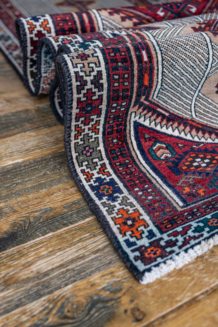 Detailed view of The Port City Rug's intricate geometric patterns and rich red and blue tones. Available at Tuck Rugs.