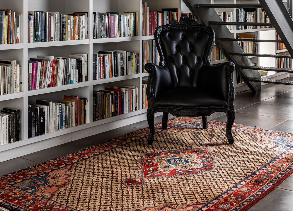 The Fort Howe Rug styled in a reading nook, adding warmth with its intricate medallion and geometric design. Available at Tuck Rugs.