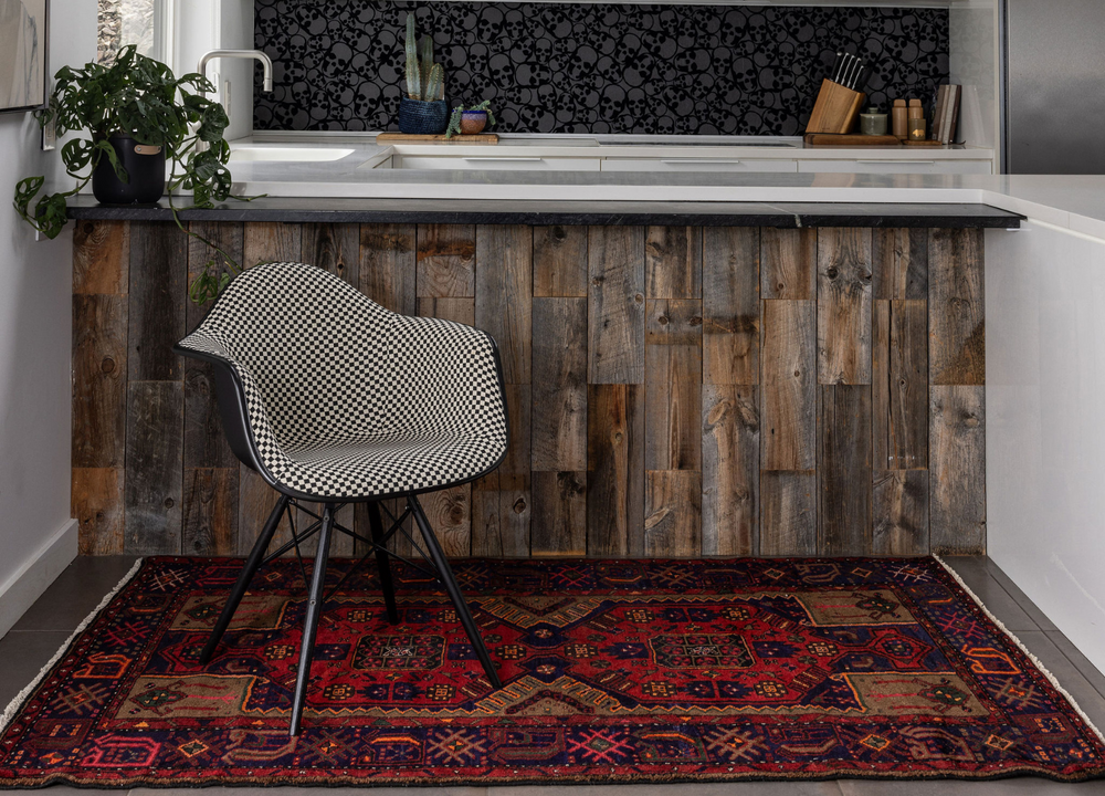 The Mecklenburg hand-knotted Turkish wool rug styled in a modern kitchen, featuring bold geometric designs in deep red and navy tones. Available at Tuck Rugs.