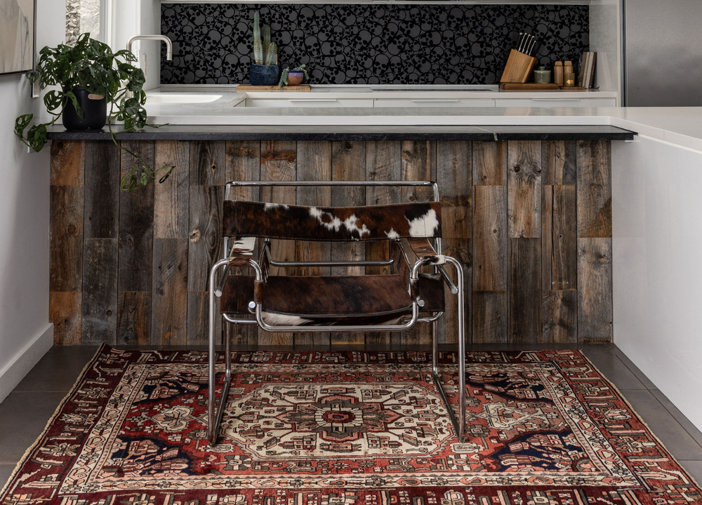 The Nature Park Turkish wool rug styled in a rustic kitchen, featuring vibrant geometric patterns in red and navy tones. Available at Tuck Rugs.