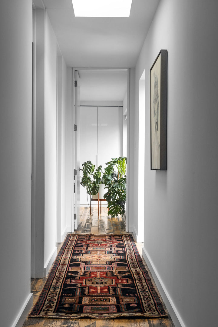 Long view of The Leinster Turkish wool runner in a modern hallway, showcasing its intricate patterns. Available at Tuck Rugs.